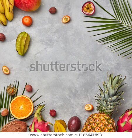 Various Juicy Exotic Fruits Coconut Lychees Carom Pineapple Palm Leaves And Empty Brown Wooden Stockfoto © artjazz