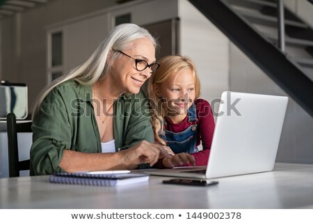 Stock foto: Granddaughter Showing Her Grandmother How To Use A Computer