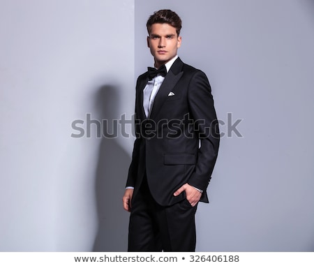 Stockfoto: Attractive Man In Black Tuxedo Standing With Hands In Pockets