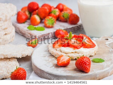 Foto d'archivio: Healthy Organic Rice Cakes With Ricotta And Fresh Strawberries On Wooden Board And Glass Of Milk On