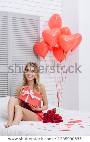 ストックフォト: Smiling Woman In Pajama Holding Gift Box And Looking At The Camera Valentines Day Concept