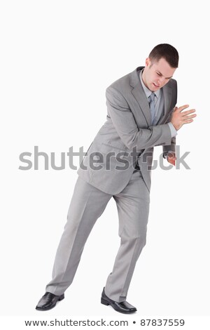 Stok fotoğraf: Portrait Of A Handsome Businessman Pushing A Wall Against A White Background