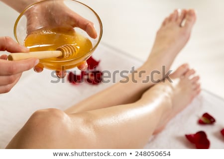 Stock fotó: Therapist Waxing Womans Leg At Spa Center