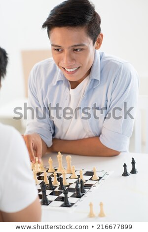 Foto stock: Young Man Contemplating His Next Chess Move