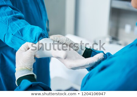 Stockfoto: Anonymous Surgeons Putting On Gloves