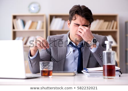 Foto stock: Drunk Businessman Drinking From A Bottle Of Whisky