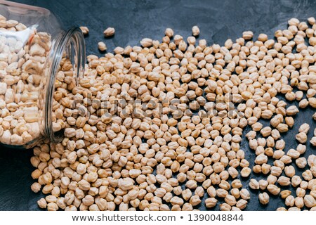 Foto stock: Chickpeas Spilled On Dark Background High Protein Vegetarian Food Garbanzo In Glass Jar Vegan Hea