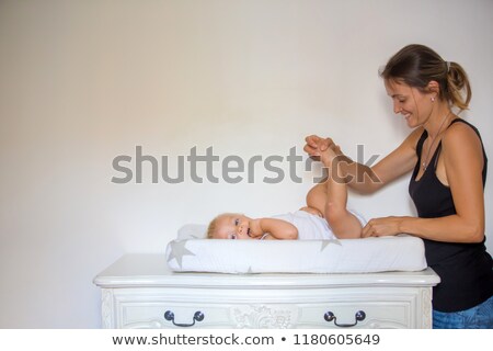 Stock fotó: Close Up Of A Baby Lying On A Changing Table While His Mother Is Changing His Nappy In The Bedroom