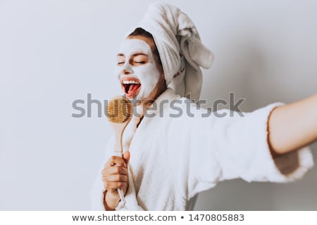 Stockfoto: Beautiful Young Woman Relaxing With Face Mask At Home Happy Joyful Woman Applying Black Mask On Fac
