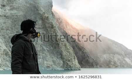 Foto stock: Young Man Tourist Makes A Selfie Standing At The Edge Of The Crater Of The Ijen Volcano Or Kawah Ije