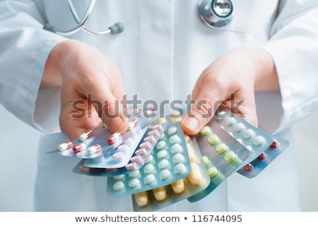 Foto d'archivio: Medical Doctor Holding Stack Of Different Pills Antibiotics And Virus Treatment Tablets On Grey Hos