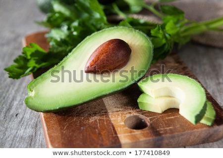 Foto d'archivio: Fresh Organic Avocado Halves On Cutting Board On Old Wooden Tabl