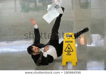 ストックフォト: Man Falling On Wet Floor In Front Of Caution Sign