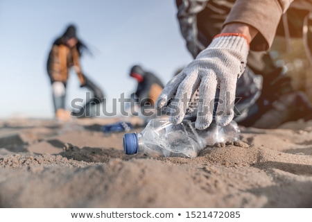 Stock fotó: Man In Gloves Pick Up Plastic Bags That Pollute Sea Problem Of Spilled Rubbish Trash Garbage On The