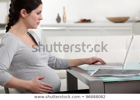 Stok fotoğraf: Pregnant Woman With Fetal Ultrasound Image At Home