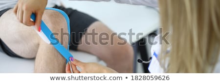 Foto stock: Physiotherapist Applying Kinesiology Tape For Painful Shoulder