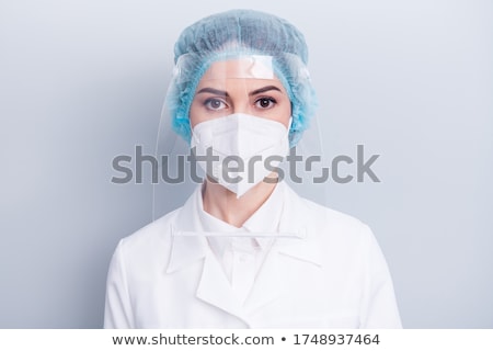 Stock photo: A Surgeons Woman Wearing Protective Uniformscaps And Masks An