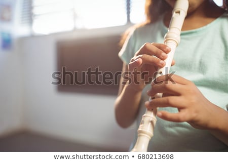 Stock foto: Girl Practicing Flute In Classroom