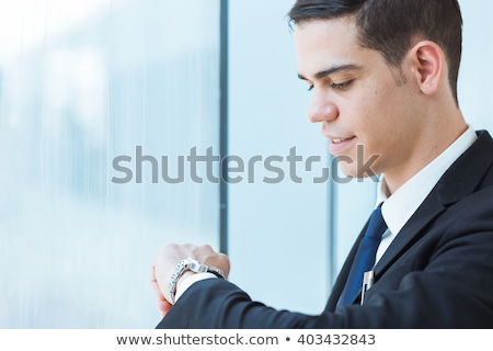 Stok fotoğraf: Businessman Looking At His Wrist Watch In A Busy City