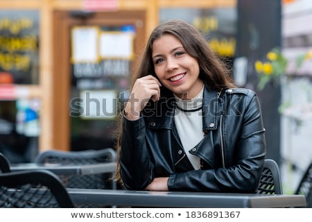 ストックフォト: The Girl With Dark Hair At A Table In The Restaurant Waiting For My Order Of Cocoa Curly Hair Bea