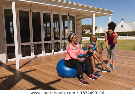 Stock fotó: Front View Of Female Trainer Training Senior People In Performing Exercise On Ball At Home