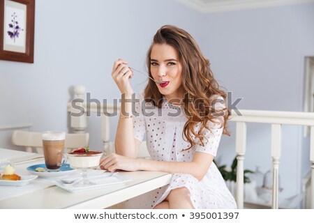 Foto stock: Portrait Of A Cute Young Woman Sitting At The Table With Cake