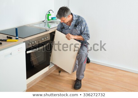 Foto d'archivio: Handyman Fixing Sink Door