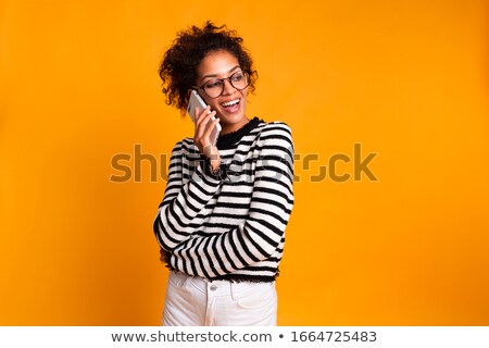 Stockfoto: Happy Emotional African Woman Posing Isolated Over Yellow Background Talking By Mobile Phone