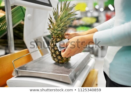 Сток-фото: Woman Weighing Pineapple On Scale At Grocery Store