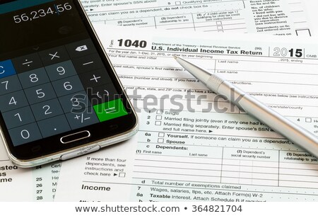 Foto d'archivio: Calculator App On Smartphone With 2015 Irs Form 1040