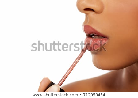 Foto d'archivio: Close Up Of Young Woman Applying Lipgloss