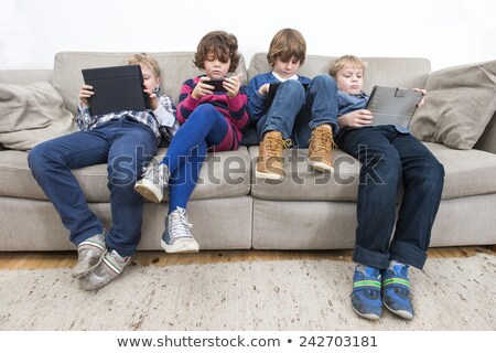 Foto stock: Bored Children Gaming On A Couch