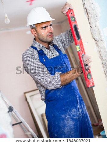 Foto stock: Builder With A Spirit Level On A Wall