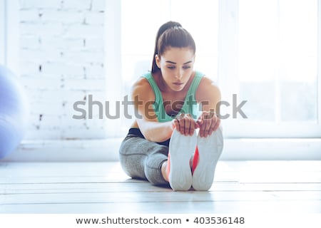 Stok fotoğraf: Women Stretching Legs In Sports Club