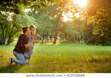 [[stock_photo]]: Mother With Child Is Started Up With Soap Bubbles