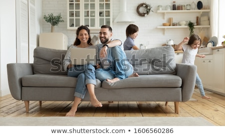 [[stock_photo]]: Couple With Daughter And Laptop On Sofa