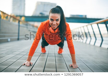 Stok fotoğraf: Young Woman Exercises On The Promenade After Running