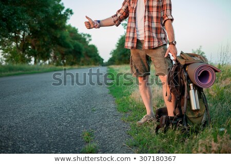 Stock photo: Young Smilimg Caucasian Tourist Hitchhiking Along A Road