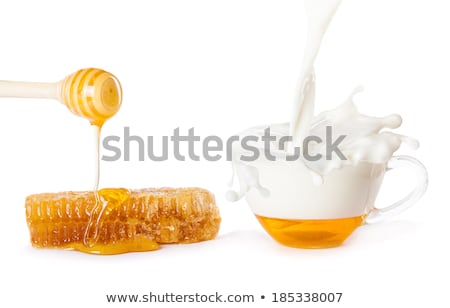 ストックフォト: Honey Drops From A Honey Dipper In A Jar With Milk