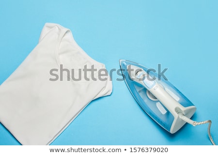 Foto stock: Woman Ironing T Shirt With Electric Iron