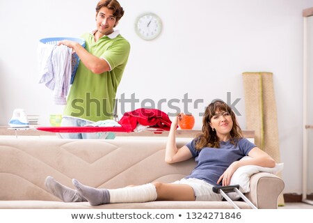 Stock fotó: Husband Helping Leg Injured Wife In Housework