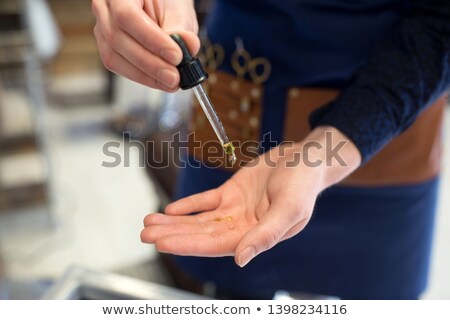 Zdjęcia stock: Barber Dropping Serum From Dropper To His Hand