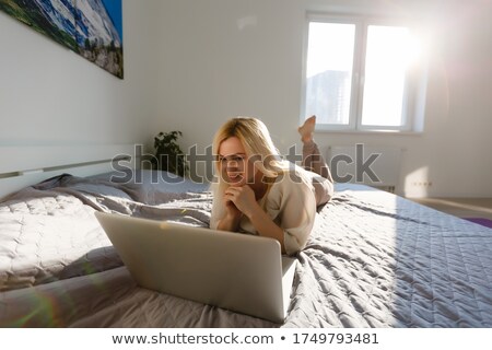 Foto stock: A Young Woman Laying On The Floor In Front Of Her Laptop And Ins