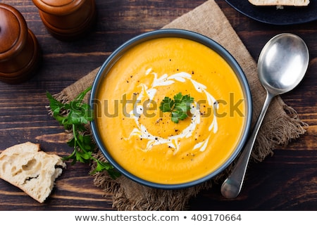 商業照片: Pumpkin And Carrot Soup With Cream And Parsley On Dark Wooden Background Top View