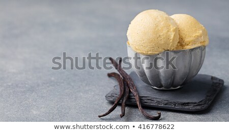 Foto d'archivio: Vanilla Ice Cream With Vanilla Pods In Metal Vintage Bowl Homemade Organic Product Slate Background