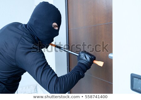 Foto stock: House Robbery - Robber Trying Open Door With Crowbar