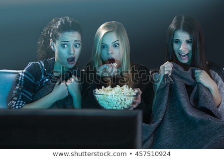 Stock photo: Woman Watching A Scary Movie And Eating Popcorn