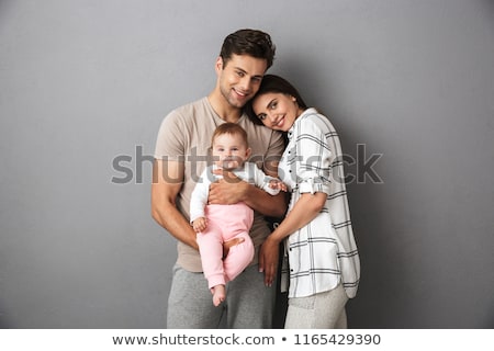 Foto stock: Portrait Of A Smiling Young Family With Their Little Baby Girl