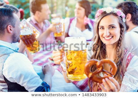 Stok fotoğraf: Woman Toasting To The Camera With Glass Of Beer In Bavarian Pub