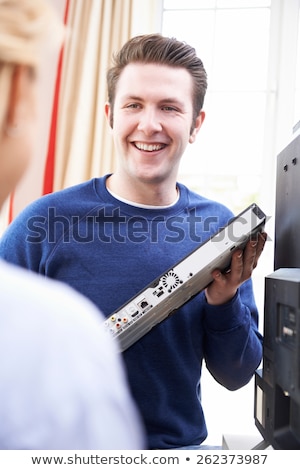 Foto stock: Television Engineer Installing New Television At Home